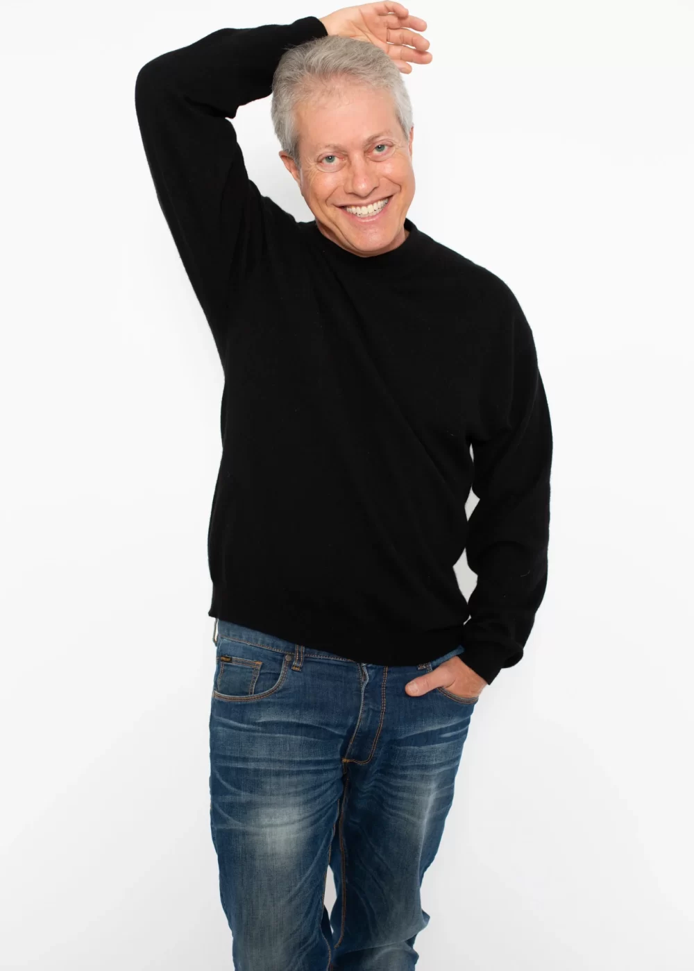 Scott Shimberg standing in black sweater and jeans arm above PNG